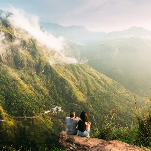 The couple greets the sunrise in the mountains. Man and woman in the mountains