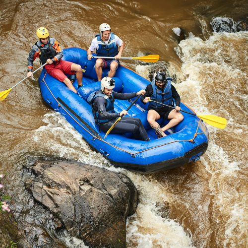 Through the rapids. High angle shot of a group of young friends white water rafting.